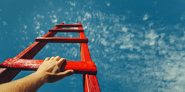 Person climbing a red wooden ladder into the sky.